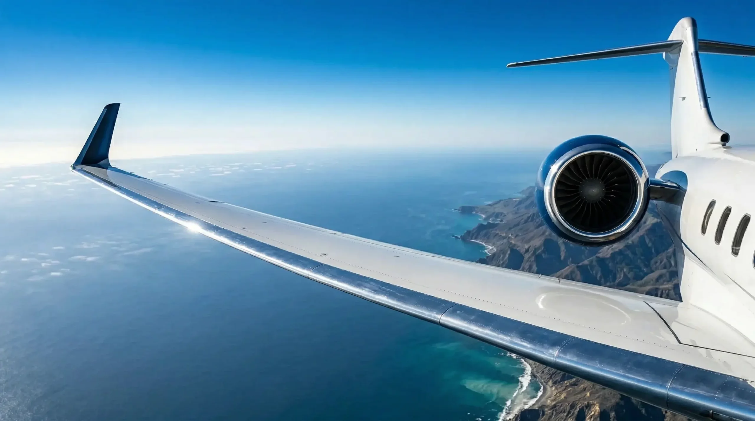 Bombardier Global 7500 winglet and engine detail in aerial view over coastline at cruising altitude