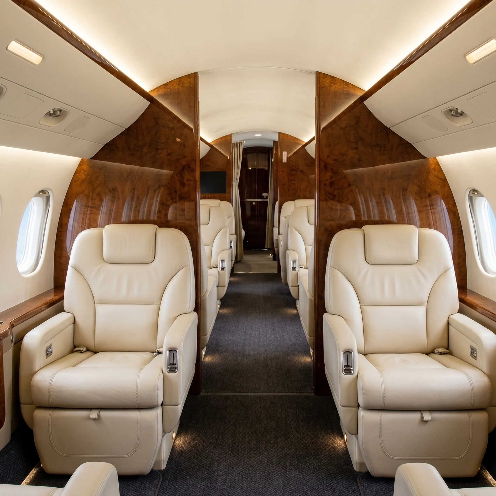 Dassault Falcon 7X private jet cabin interior with cream leather seating and wood panel details
