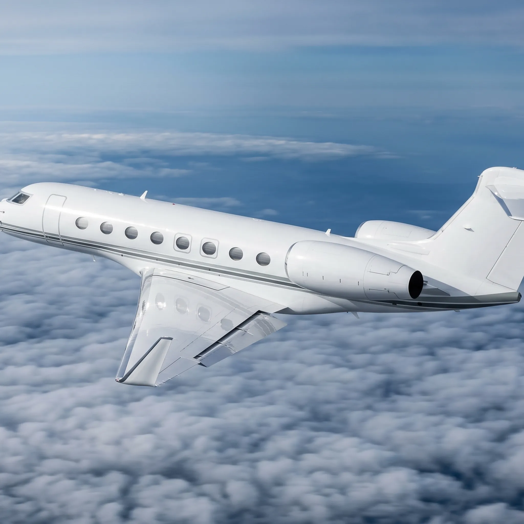 Business jet flying above cloud layer at high altitude on international private aviation route